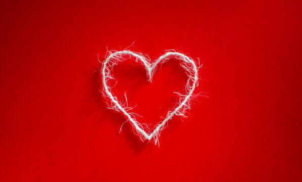 White heart on a red background. Photo taken with selective focus and noise effect