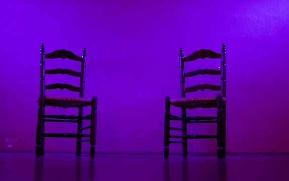 Two Simple Wooden Chairs On An Illuminated, Empty Stage