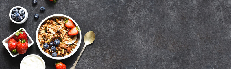 Granola with yogurt, seeds and coconut on a black background.