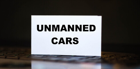 UNMANNED CARS. Development concept on paper on laptop background.