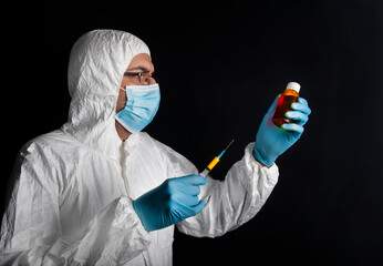 Young specialist in a protective suit, glasses, gloves and a mask at the time of medical...