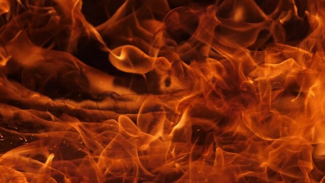 Slow motion speed close up scene of moving burning pattern as background. hot as inferno flame concept, abstract beautiful fire texture with flakes of spark, black smoke from petroleum oil ignition