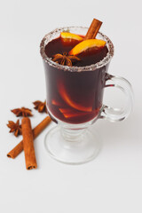 glass of christmas mulled wine with oranges and spices on white background.