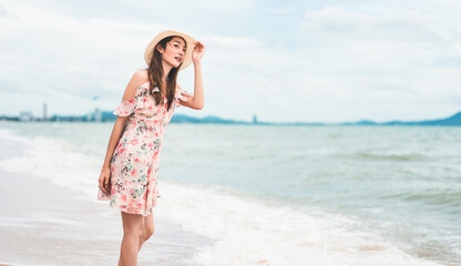 Young asian beautiful woman walk and relax on the beach sand.