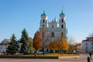 Fototapeta na wymiar Grodno. Belarus. Town square and catholic church surrounded by autumn trees.