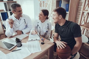 Male doctor laughing while looking at a basketball