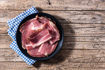 Dried and smoked meat slice on wooden table.Top view. Copy space