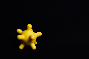 Obraz premium Yellow colorful bright isolated spiky ball toy on a black background, macro