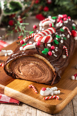 Chocolate yule log christmas cake on wooden table