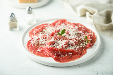 Traditional Italian beef carpaccio with grated cheese
