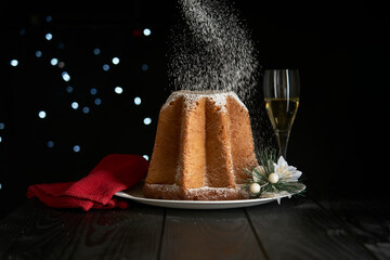 Celebrating Christmas with a snowfall of powdered sugar that whitens a pandoro, a typical dessert...