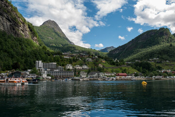 Geiranger village in Norway, surrounded by green mountains, at the end of the Geiranger fjord