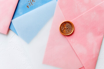Luxury blue and pink velvet envelopes and transparent card for text on a textured background.
