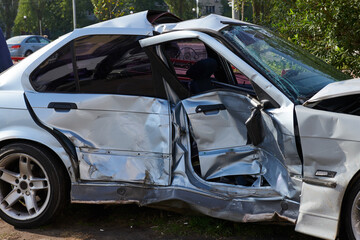 Silver car after a horrible crash accident. Front and side impact. Speeding concept photo. Life insurance. Accident beyond recovery. Side view.