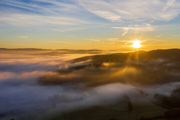Fototapeta na wymiar sun rise in the Bavarian forest with fog swathes in pastel colours