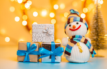Snowman and Christmas gifts on bright yellow background