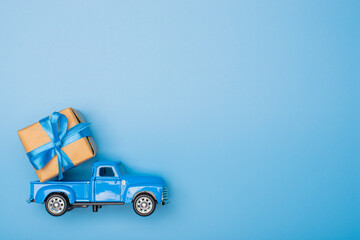Blue retro toy car delivering gift box