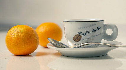 Cup of coffee with tangerines and spoon