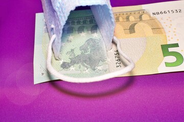 Euro banknotes, calculator and a surgical mask concept of Corona Virus