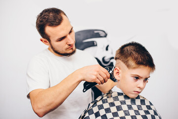 Hairdresser barbershop parihopher strechot small boy sitting on a chair