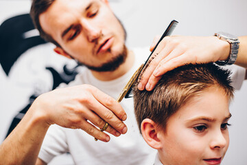 Hairdresser barbershop parihopher strechot small boy sitting on a chair
