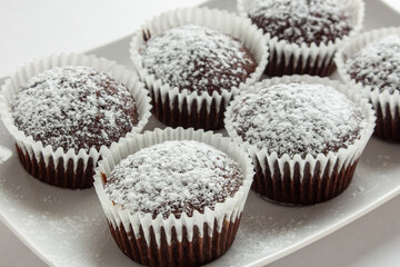 Several chocolate muffins on the white square plate