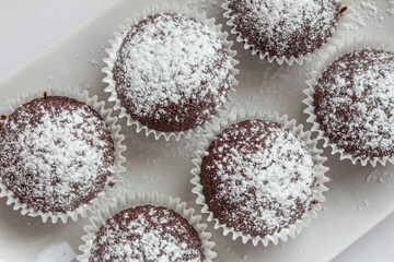 Several chocolate muffins on the white square plate