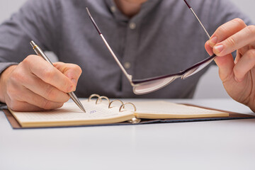 hand with pen and glasses
