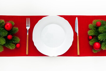 Table setting with spruce, plate, flatware on white background top view