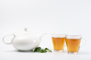 Green tea leaf and glass cup of black tea isolated on white background