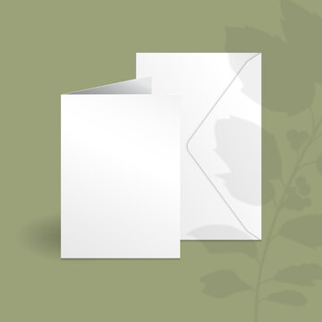 White Vertical Greeting Card And Envelope Mockup Template With Holly Berry Branch With Leaves Overlay Shadow.