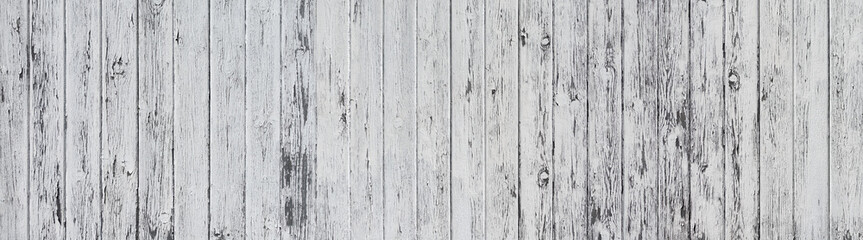 Panorama Holzwand aus vertikalen, hellgrau gestrichenen, stark verwitterten Brettern in Nahaufnahme