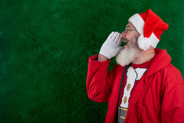 Mature bearded man with eyeglasses on face wearing Santa hat, Santa put hand to face and shouts, copy space