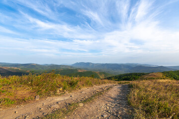 dirt road against the backdrop of beautiful mountains in summer