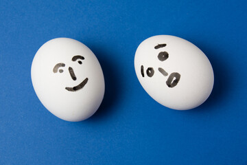 Eggs with different emotions on their faces: surprise and joy.