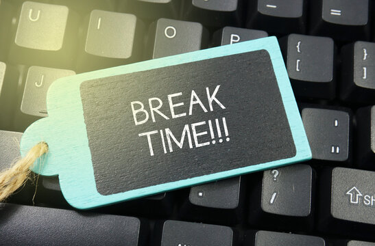 wooden tag written break time over keyboard button background