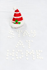 Stay home lettering from round white pills on a white background. Christmas decorations. Vertical photography. High quality photo