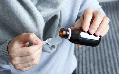 Men's hands hold a dark bottle of medicine. Treating people.