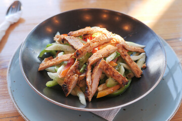 Grilled chicken and fresh vegetable salad on table.