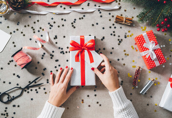 Woman hands holding Christmas gift on decorated festive table