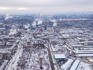 Aerial drone view of city roads and houses covered with snow.