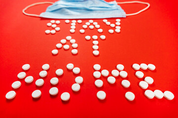 Stay home lettering from round white pills on a red background. face mask. High quality photo