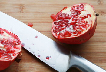 healthy fruit, pomegranate, cut into two halves with a knife, on a wooden board. Weight loss,...