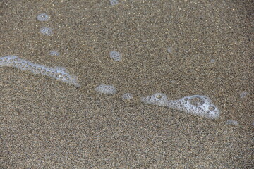 うっすらとした波が来ている砂浜