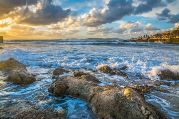 Dark clouds over Alghero rocky shore at sunset