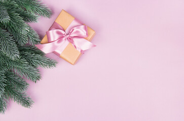Gift box with bow on empty pink background.