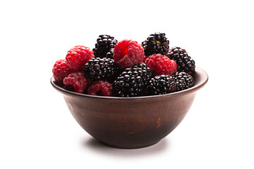 Raspberry, blackberry and mint leaf in ceramic brown bowl isolated on white