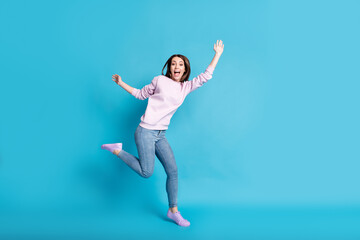 Fototapeta na wymiar Full length photo of crazy funny teenager girl enjoy carefree rest relax holiday raise hands wear good look clothes isolated over blue color background