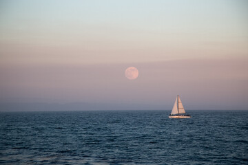 sailboat in the sea on sunset, big full moon on a background. Californian summer, tranquillity,...