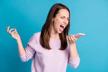 Photo of cute outraged crazy young model girl hold telephone provoked irritated open mouth yell arguing scandal break up scene concept wear violet pullover isolated blue color background